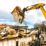 Concrete staircase being dismantled by excavator