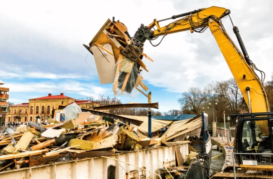 Concrete staircase being dismantled by excavator