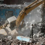 Demolition crew using safety harnesses on high-rise