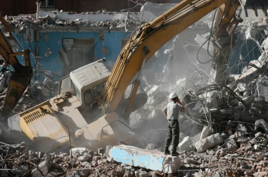 Demolition crew using safety harnesses on high-rise